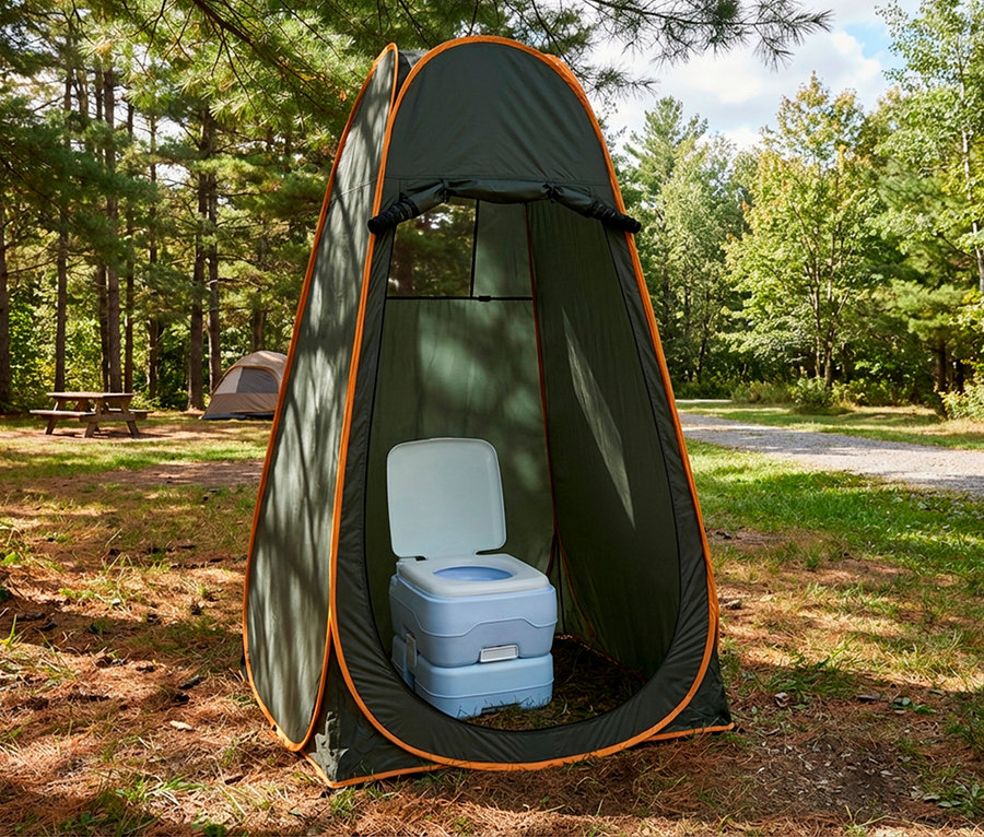 Dunkelgrünes Sichtschutzzelt mit orangefarbenem Rand steht offen auf einem Waldcampingplatz, darin eine hellblaue Campingtoilette. Im Hintergrund sind ein Picknicktisch und ein weiteres Zelt zwischen Kiefern zu sehen.