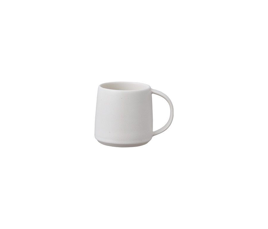 Eine einzelne, leere, hellbeige Tasse mit Henkel steht vor einem weißen Hintergrund.