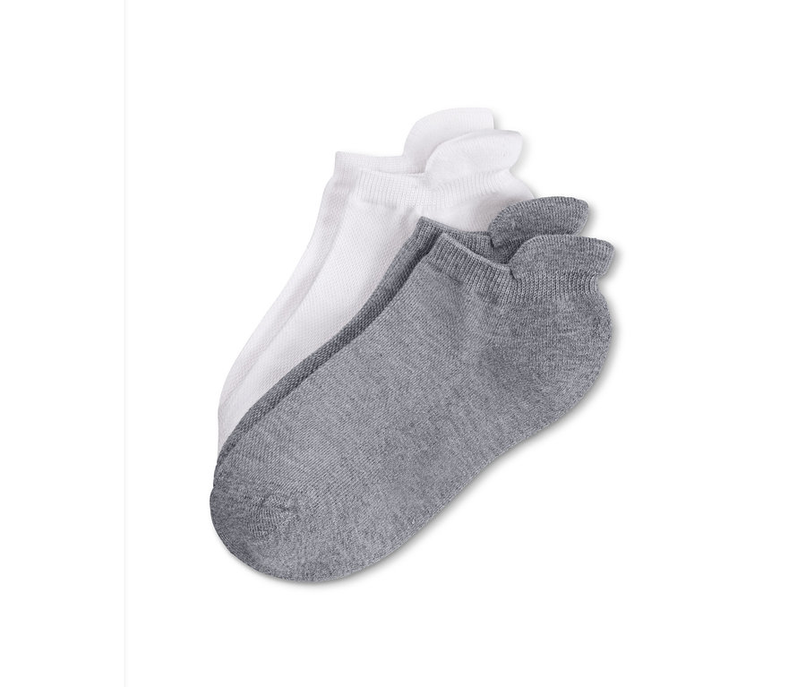 Zwei Paar Socken, ein Paar weiße und ein Paar graue, liegen auf einem weißen Hintergrund.