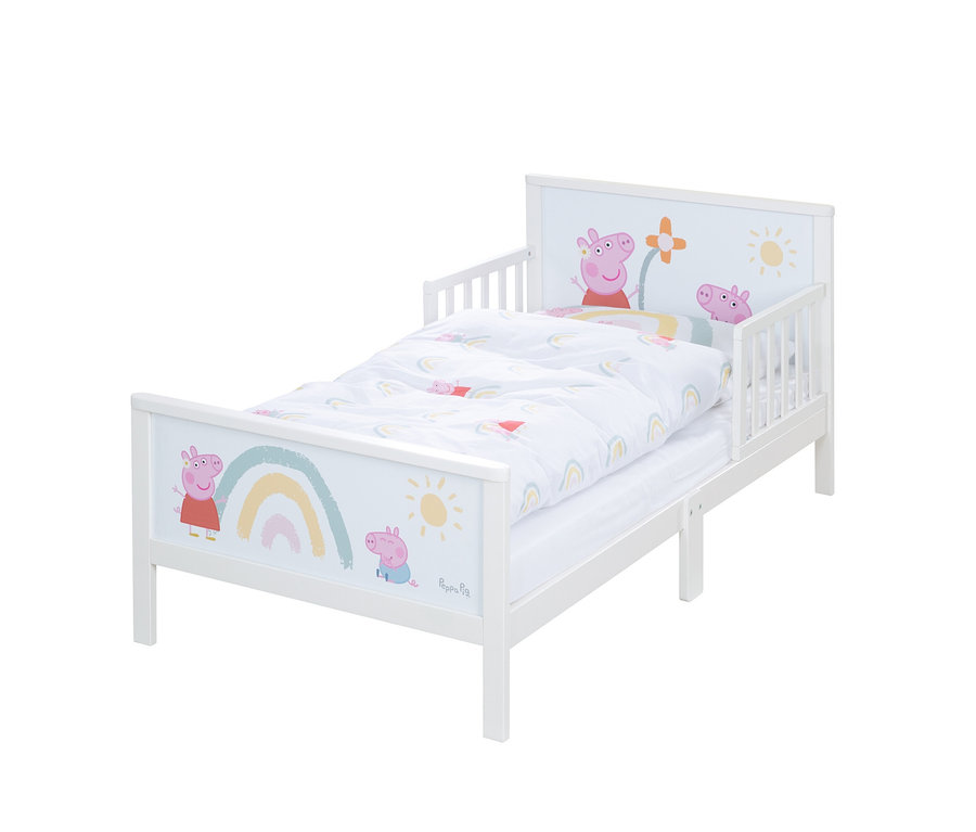 Ein weißes Kinderbett mit Peppa Wutz-Motiven und einer weißen Bettdecke mit Regenbogen darauf.