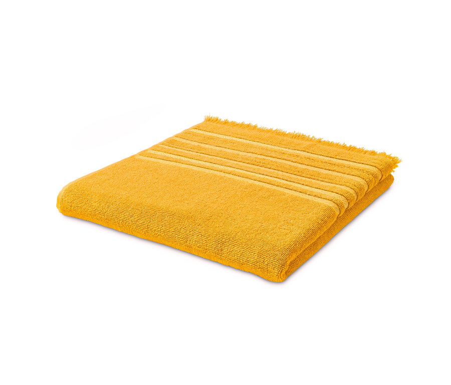 Ein gelbes Fransen-Badetuch liegt gefaltet auf einem weißen Hintergrund.