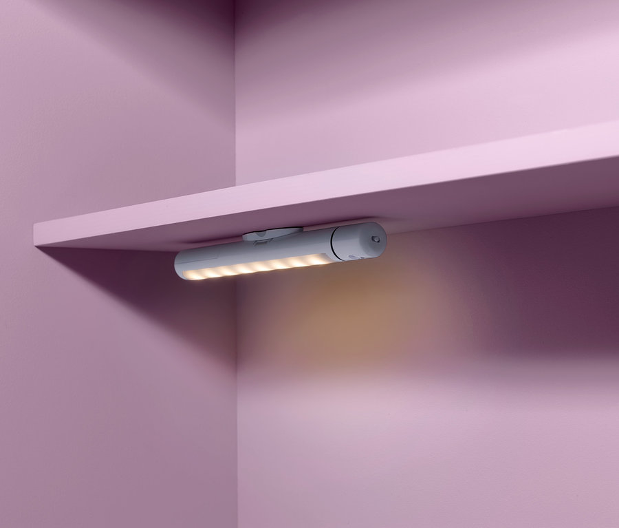 Eine LED-Multifunktionsleuchte ist an der Unterseite eines Regals befestigt.