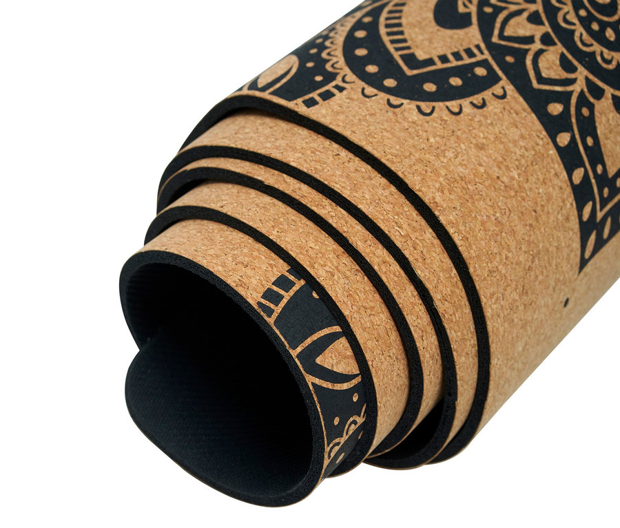 Teilweise aufgerollte Kork-Yogamatte mit schwarzem Mandala-Muster.