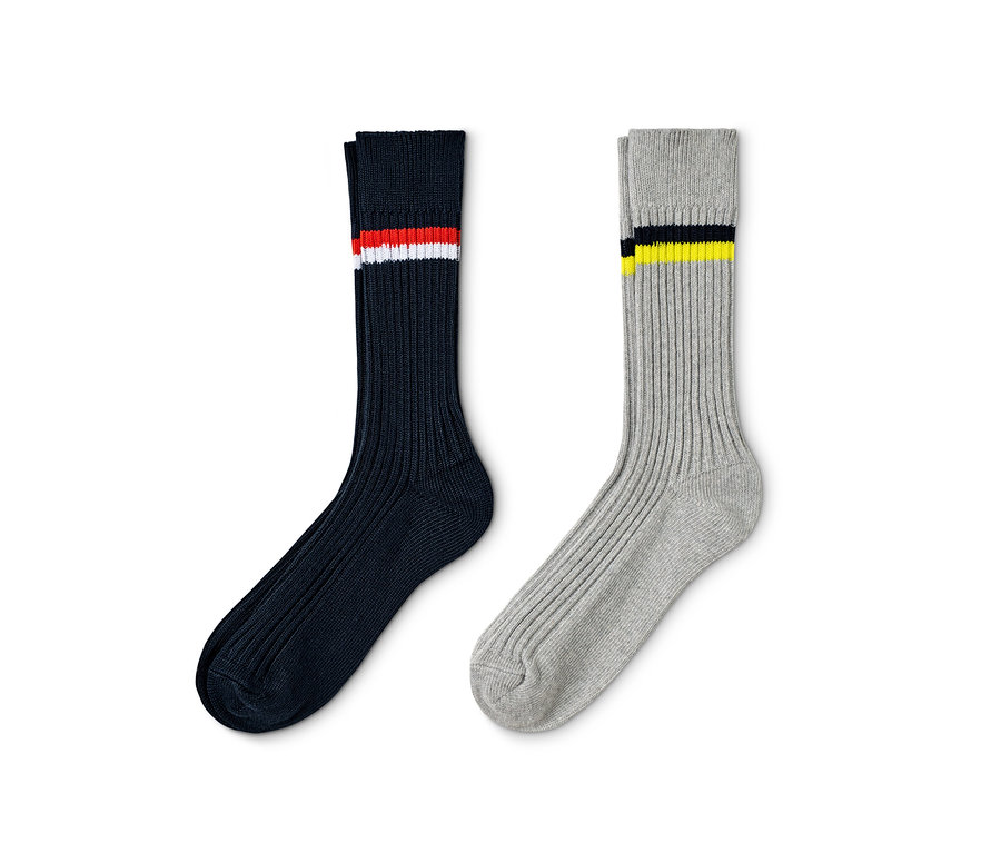 Zwei Paar Rippstrick-Socken: Marineblau mit roten und weißen Streifen und Grau mit schwarzen und gelben Streifen.