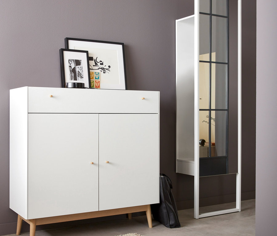 In einem Zimmer steht eine Germania-Kommode »Monteo« in Eiche-weiß. Darauf stehen zwei Bilderrahmen. Rechts steht ein Spiegel und auf dem Boden liegt ein beiger Teppich.