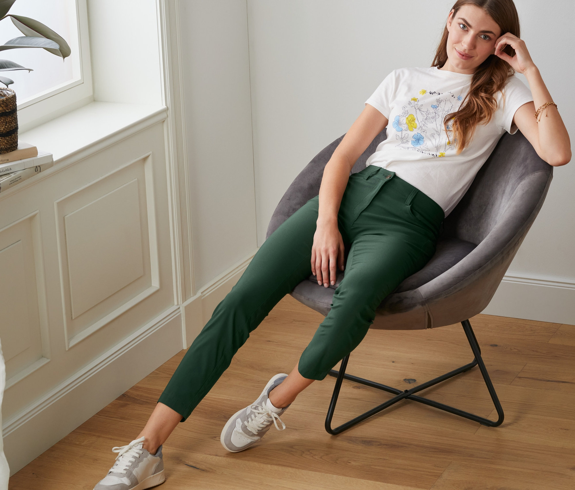 Eine Frau sitzt in einem Sessel und trägt eine Bengalin-Hose.