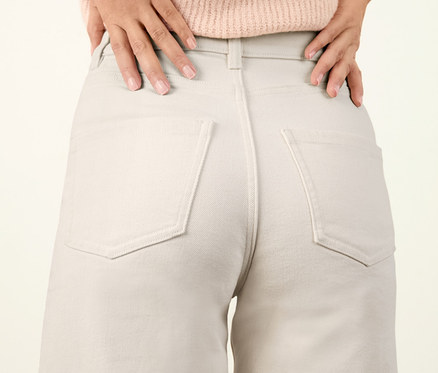 Frau posiert in weißer Culotte-Jeans.