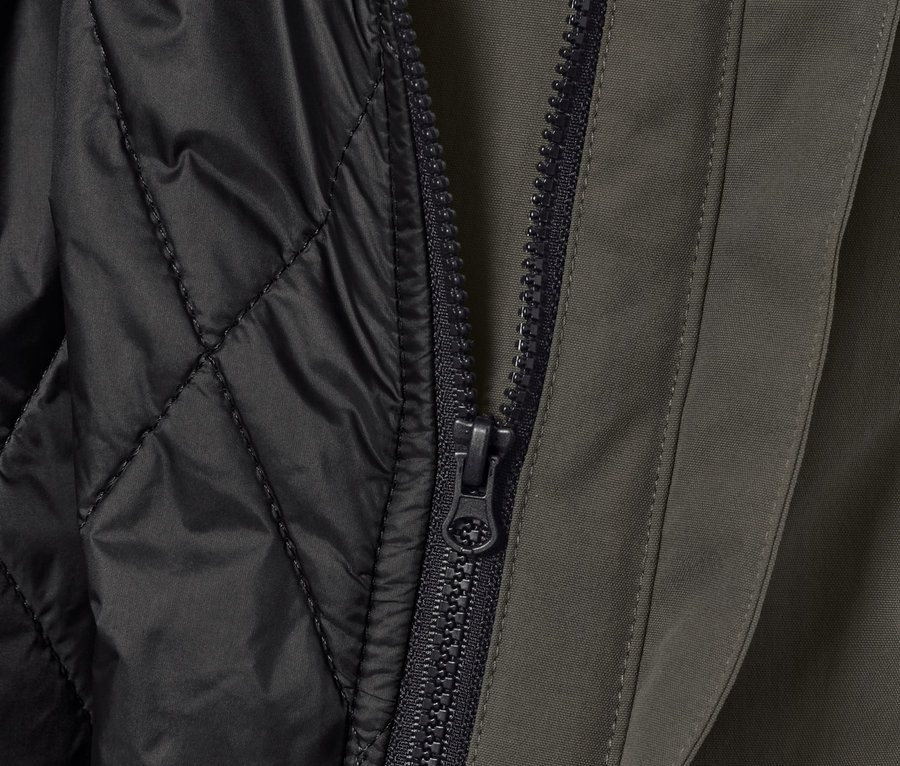 Detailansicht einer 3-in-1-Outdoorjacke mit Weste, Reißverschluss und schwarzer, gesteppter Innenschicht.