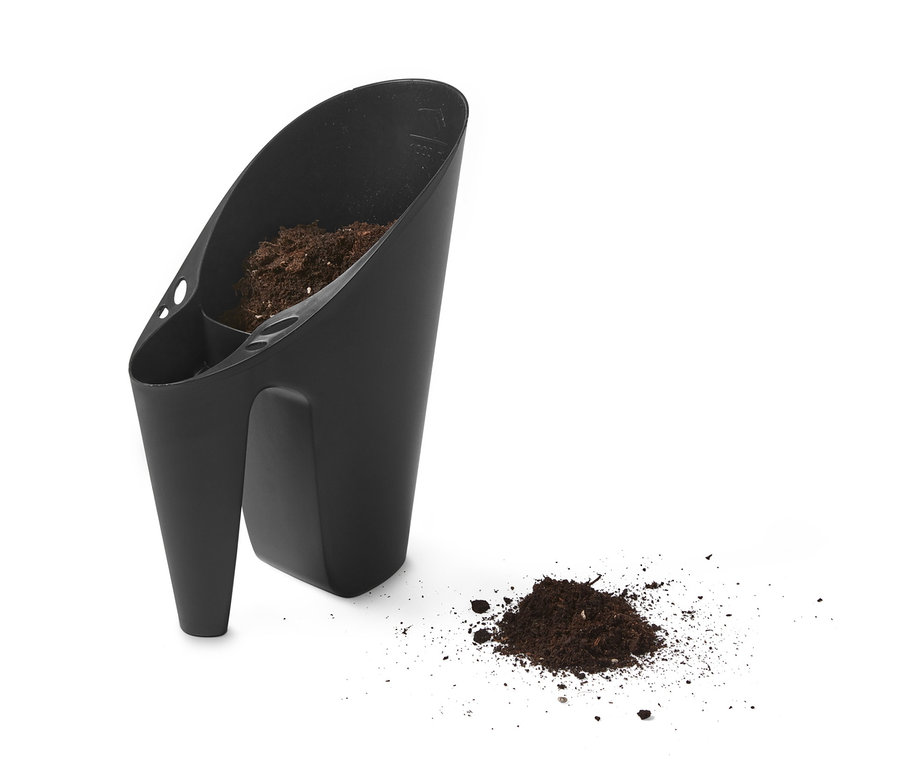 Schwarzes Gärtner-Set mit Erde drin und einem Erdhaufen daneben.
