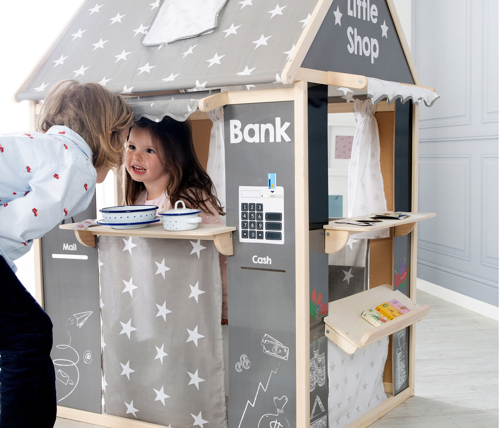Junge schaut in roba Spielhaus »Sterne«, in dem ein kleines Mädchen steht.