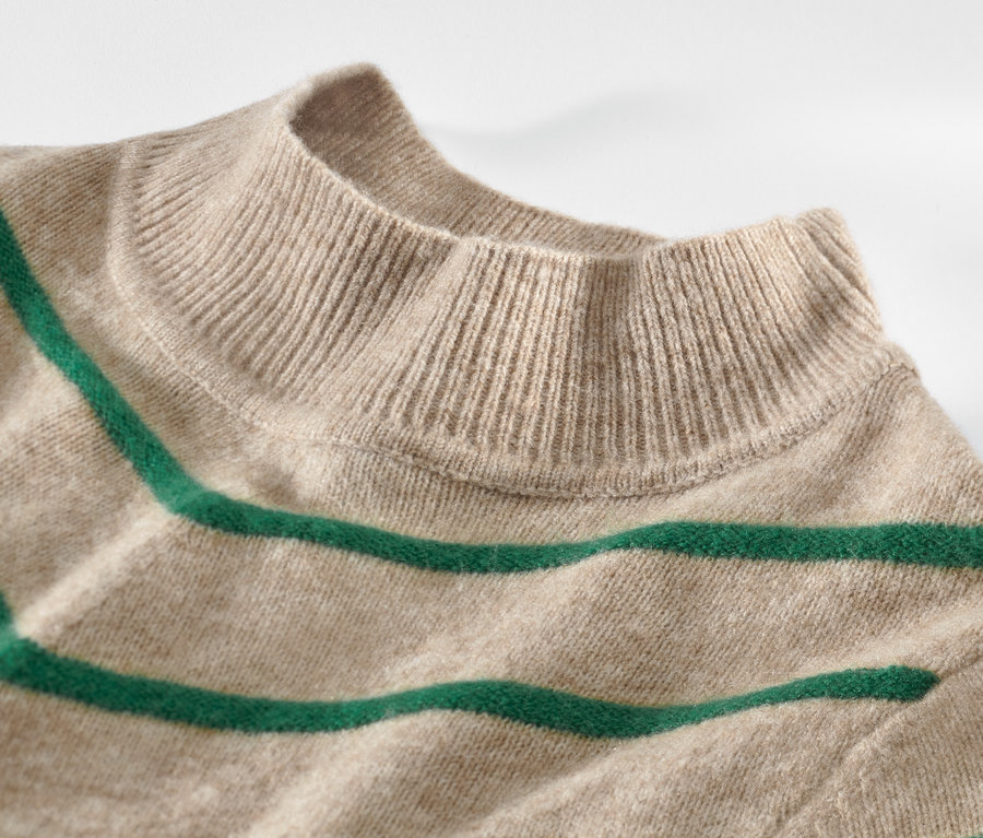 Detailansicht eines cremefarbenen, gestreiften Strickpullovers mit Stehkragen.