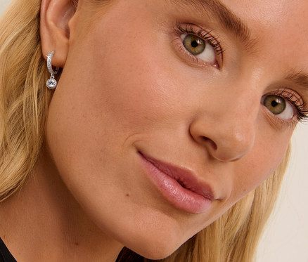 Blonde Frau trägt 925 Silber Creolen Zirkonia.