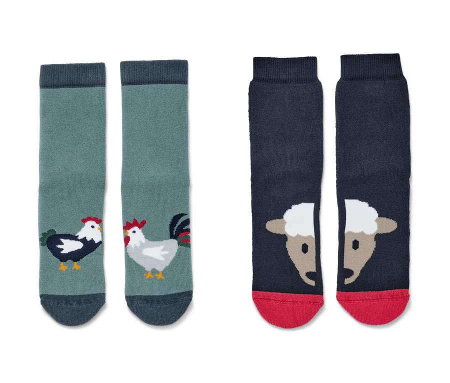 Zwei Paar Kleinkind-Antirutsch-Socken, Farm. Ein Paar ist grün mit Hähnen, das andere dunkelblau mit Schafen.