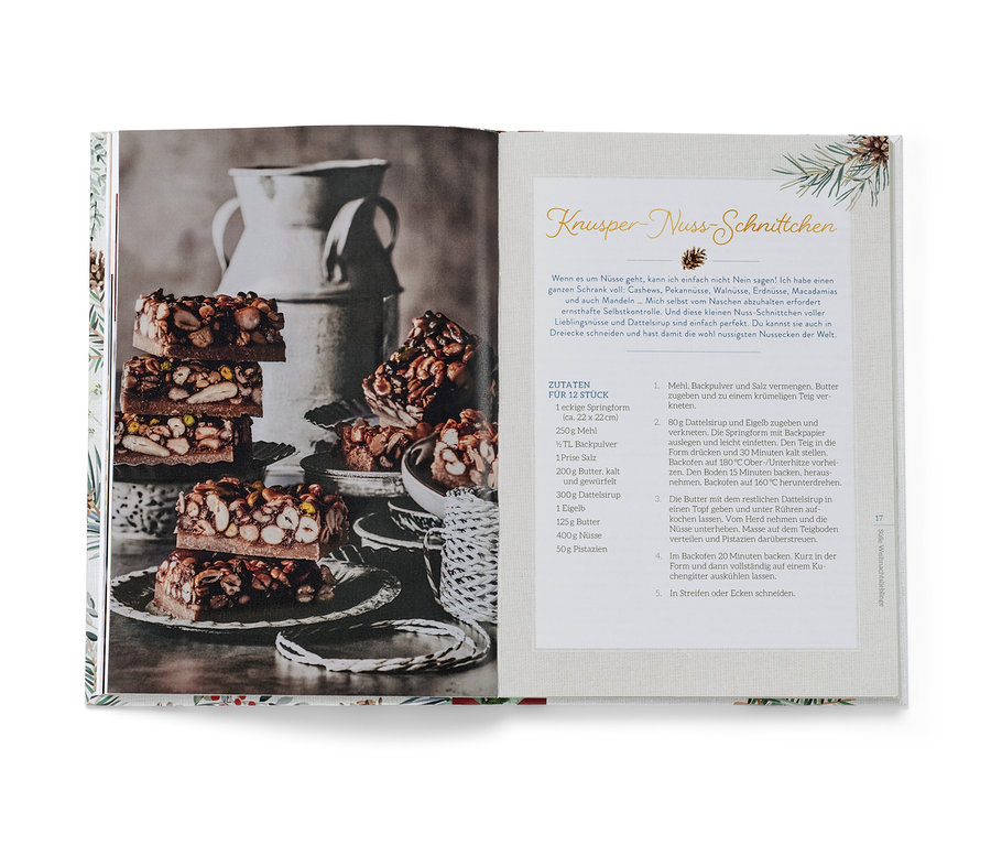 Aufgeschlagenes Buch mit einem Foto von geschichteten Nussriegeln und einem Rezept, mit dem Buch »Christmas is a feeling«.