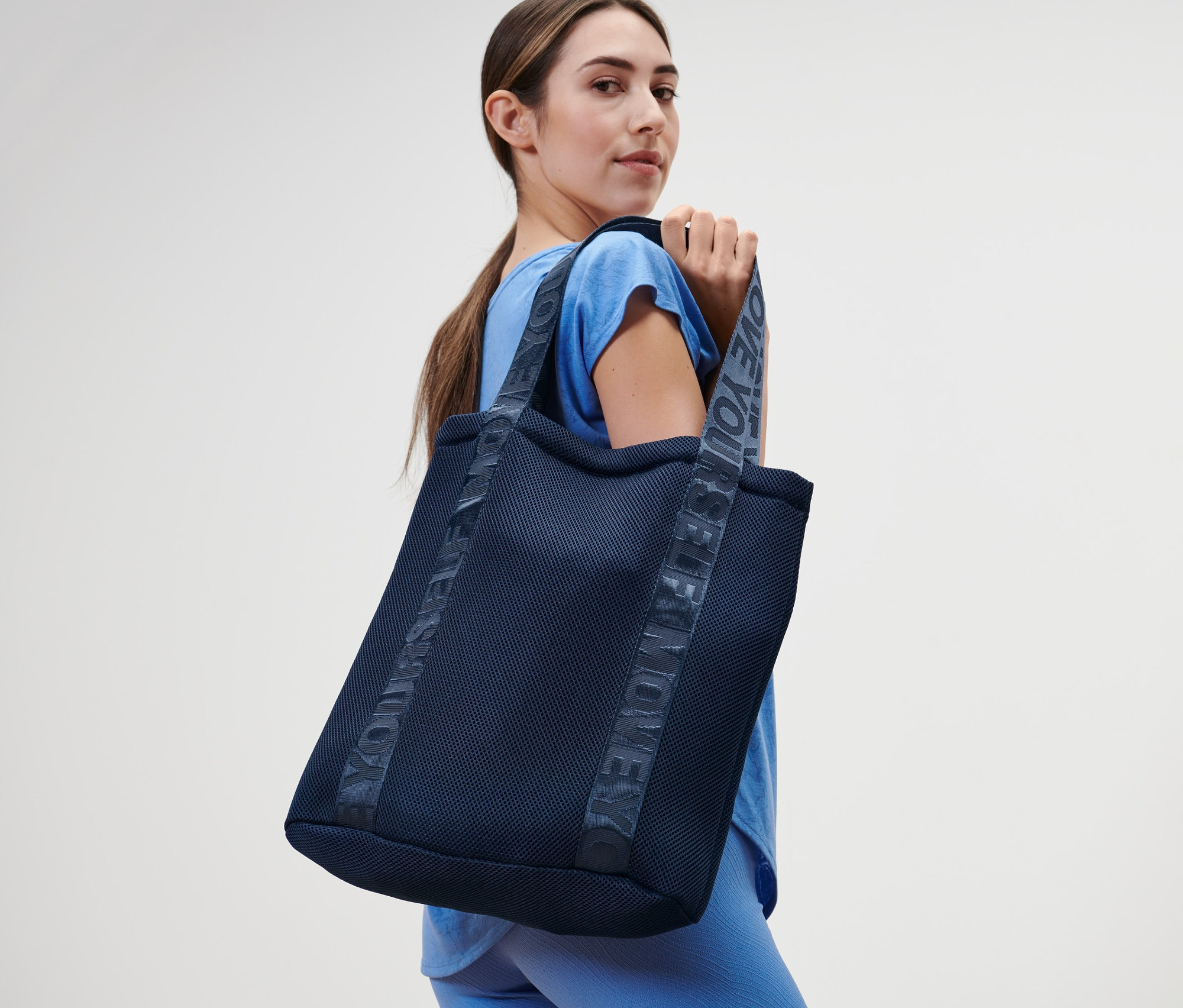 Frau hält einen Sportbeutel.