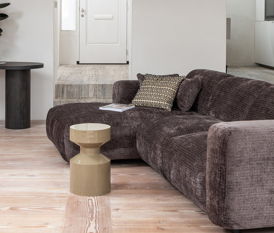 Wohnzimmer mit braunem Sofa, beigem Woood Ferry Beistelltisch aus Metall und dunklem, rundem Tisch mit Pflanze.