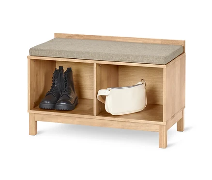 Sitzbank mit Stauraum mit schwarzen Stiefeln und einer cremefarbenen Handtasche darin.