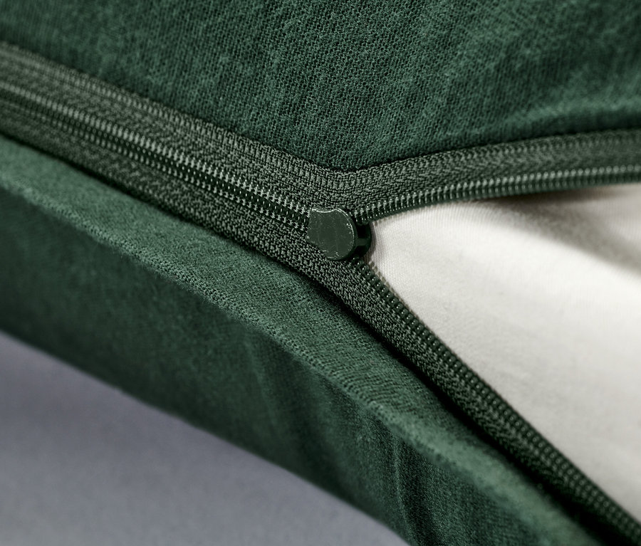 Nahaufnahme eines Reißverschlusses eines grünen Biber-Kopfkissenbezugs.