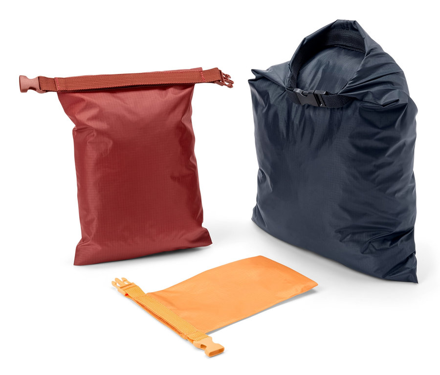 Drei wasserfeste Packsäcke in den Farben Rot, Dunkelblau und Orange.
