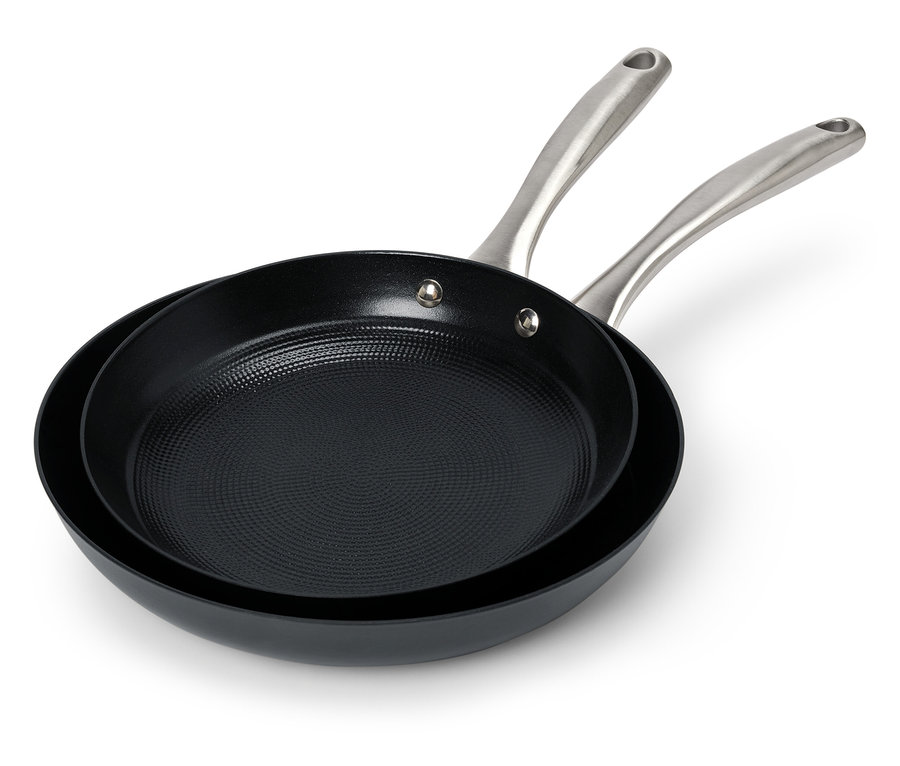 Zwei schwarze Bratpfannen mit Stahlgriffen liegen übereinander.