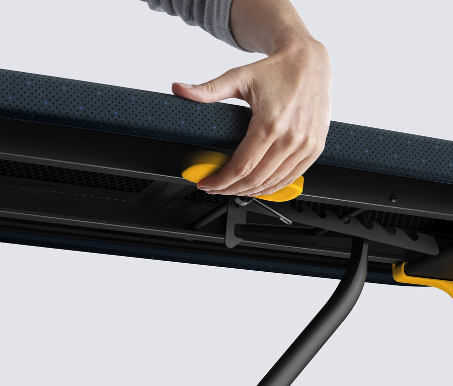 Eine Hand drückt einen gelben Knopf an einem Klapptisch.