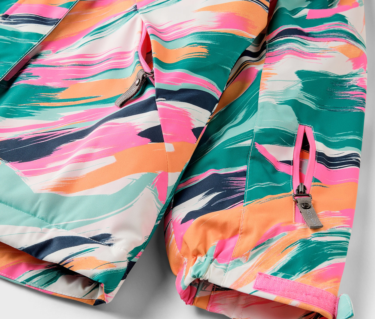 Detailansicht einer bunten Jacke mit Reißverschluss.