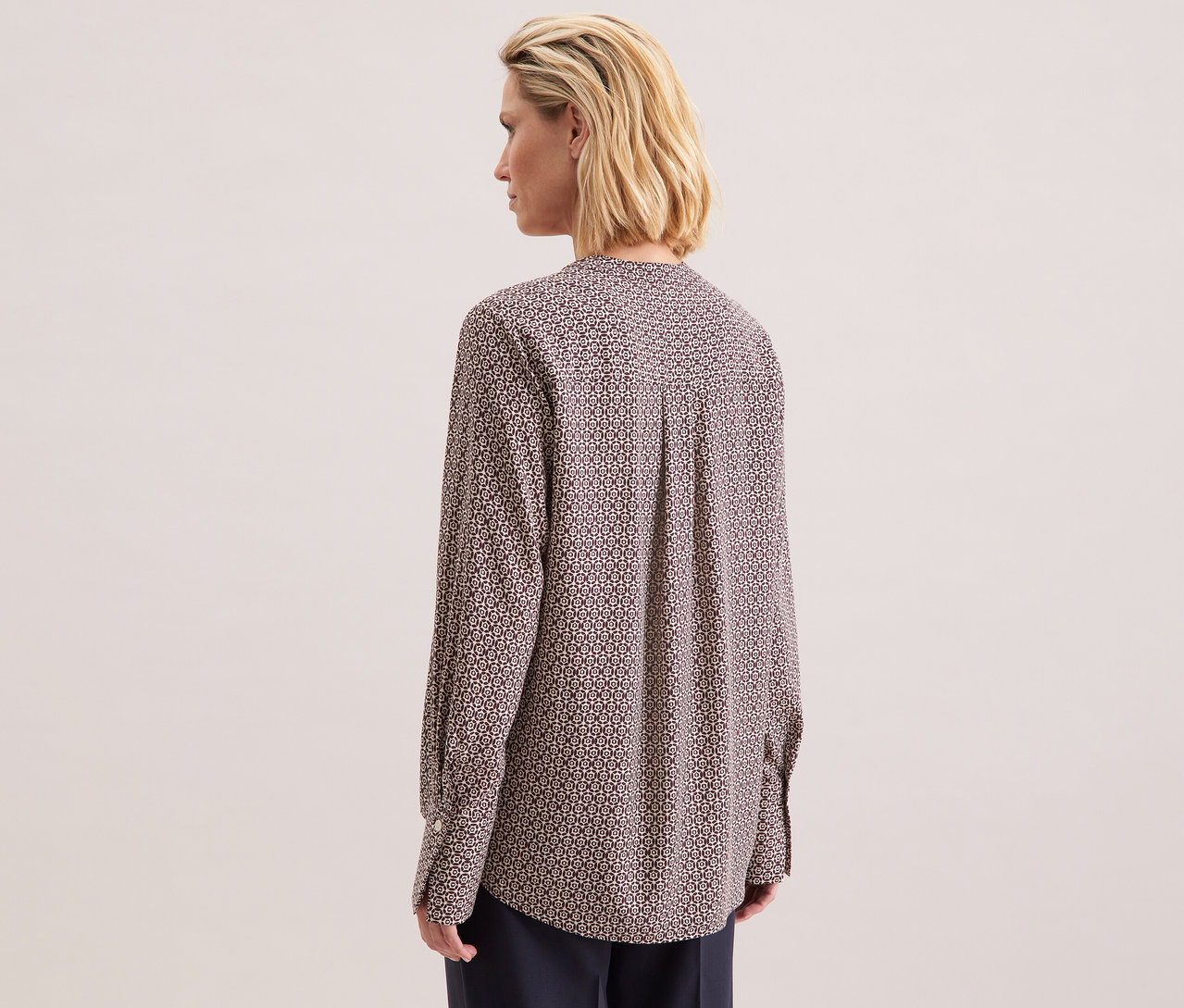 Frau von hinten, die eine Seidensticker Tunika aus Viskose mit ecru-burgundy Alloverprint trägt.