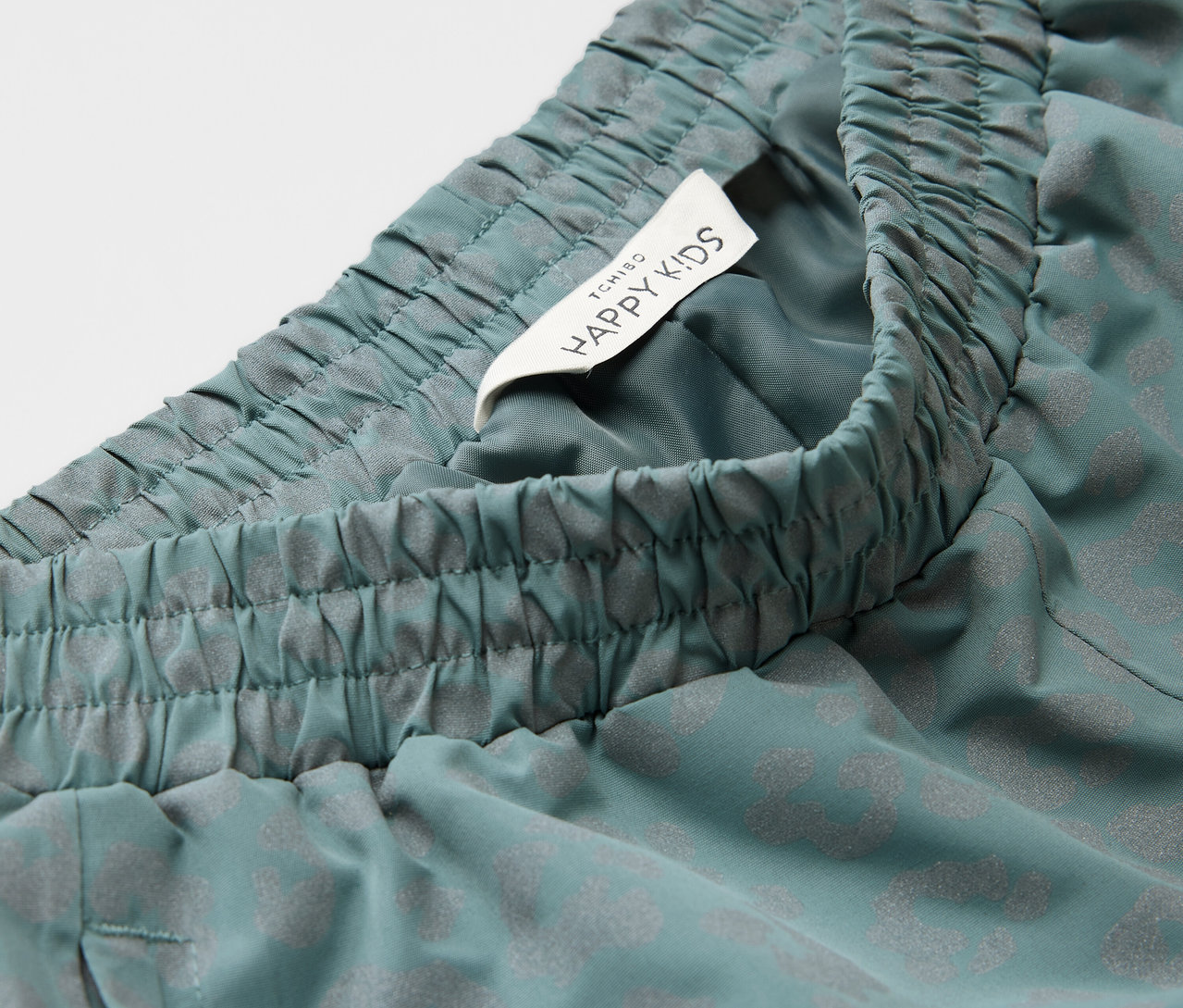 Detailaufnahme einer Kinder-Regenhose mit reflektierenden Elementen.