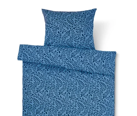 Hellblaue Bettwäsche mit dunkelblauem Blättermuster und Kissen.