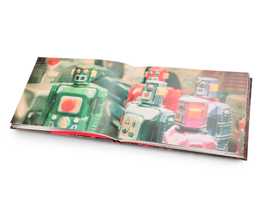 Offenes Buch mit Abbildungen von grünen, silbernen und roten Retro-Robotern.
