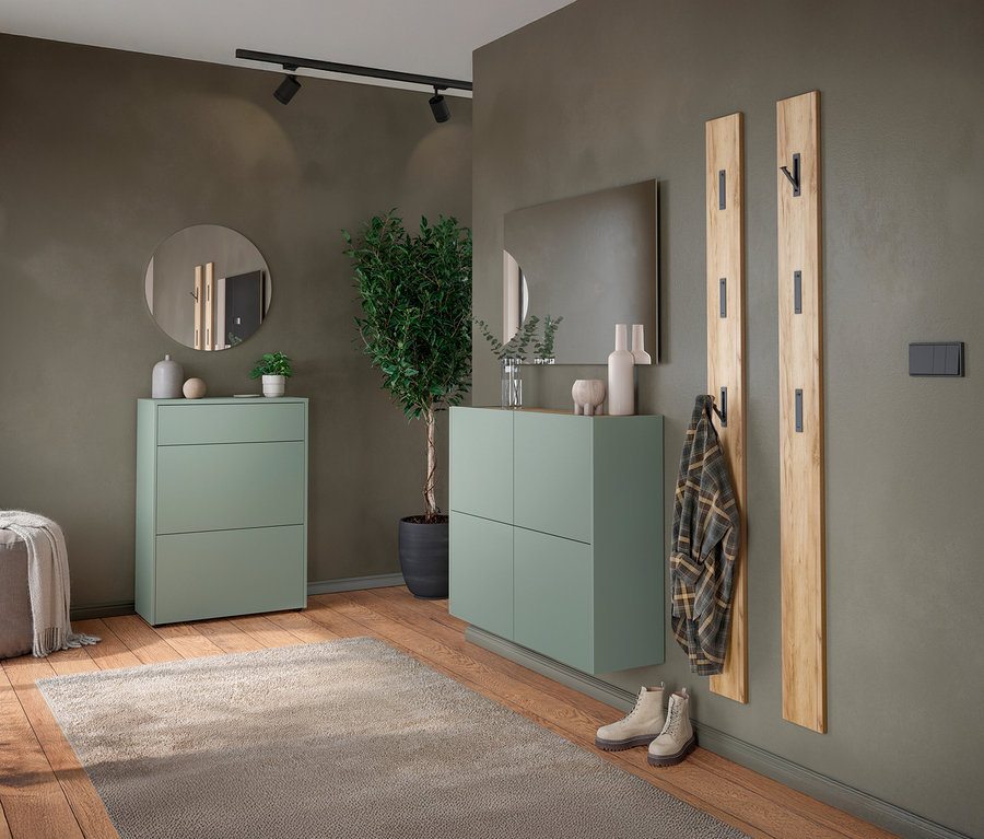 Eingangsbereich mit grünem Schuhschrank, Spiegel und Garderobenpaneelen an einer olivgrünen Wand.