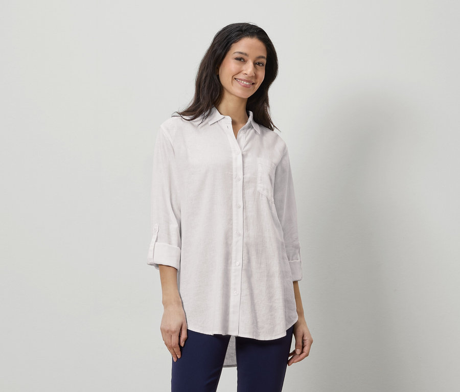 Frau trägt ein weißes Leinenhemd und marineblaue Hosen.