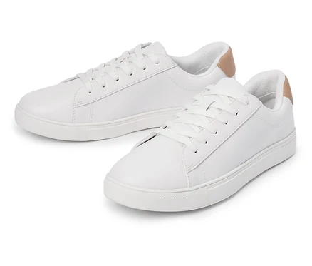Zwei weiße Turnschuhe mit Schnürsenkeln und hellbraunem Detail an der Ferse liegen nebeneinander.