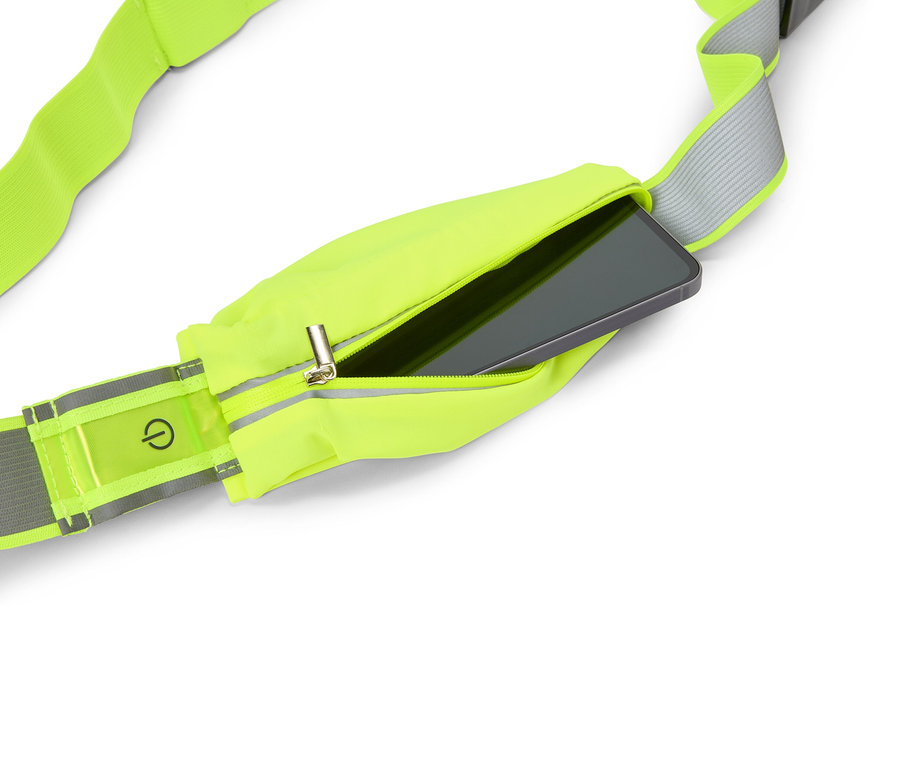 Neon-gelber Laufgürtel mit Reißverschlusstasche, in der ein Smartphone steckt. Ein Ein-/Ausschalter-Symbol ist auf einem reflektierenden Streifen zu sehen.