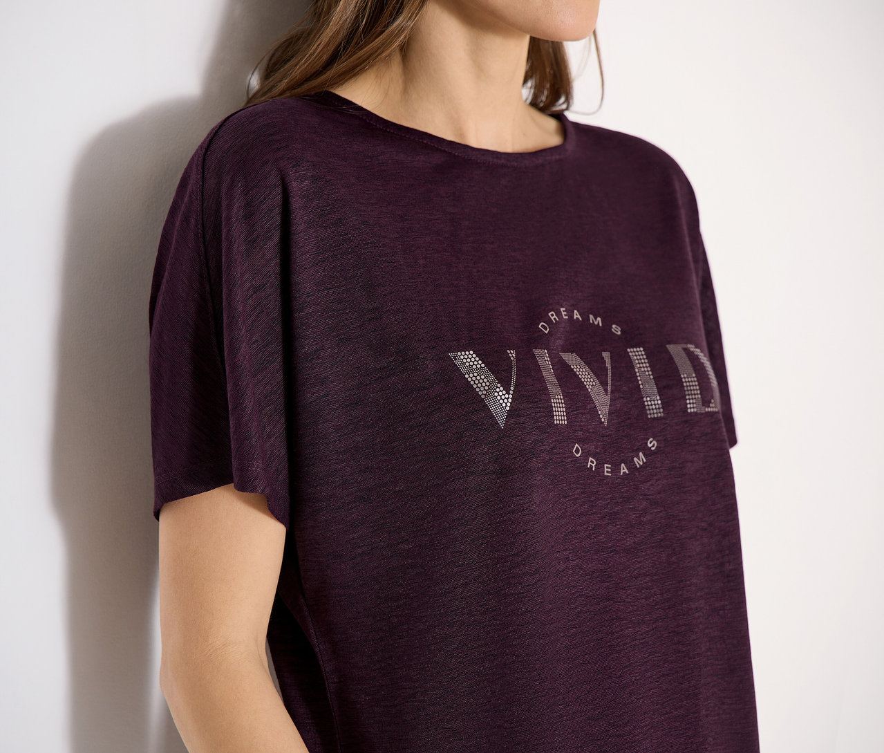 Frau trägt ein burgunderrotes CECIL Kurzarmshirt mit dem Aufdruck "VIVID DREAMS".