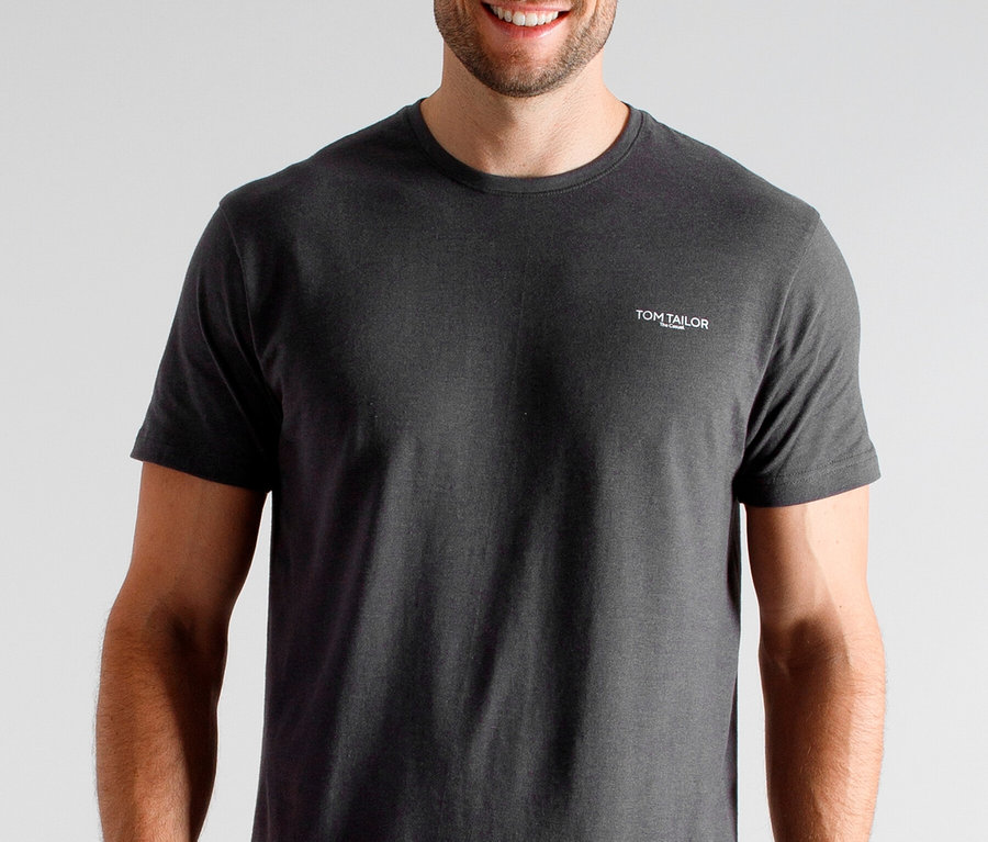 Mann mit dunklem Tom Tailor T-Shirt, der lächelt.
