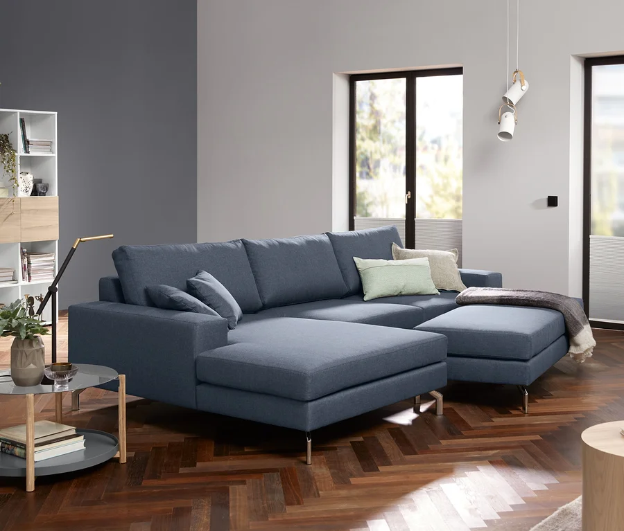 Blaues Ecksofa mit Glas-Couchtisch.