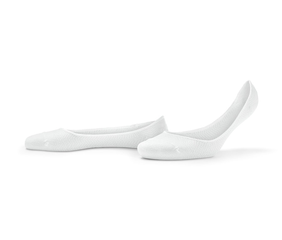 Zwei Paar weiße Sneaker-Füßlinge liegen auf dem Boden.