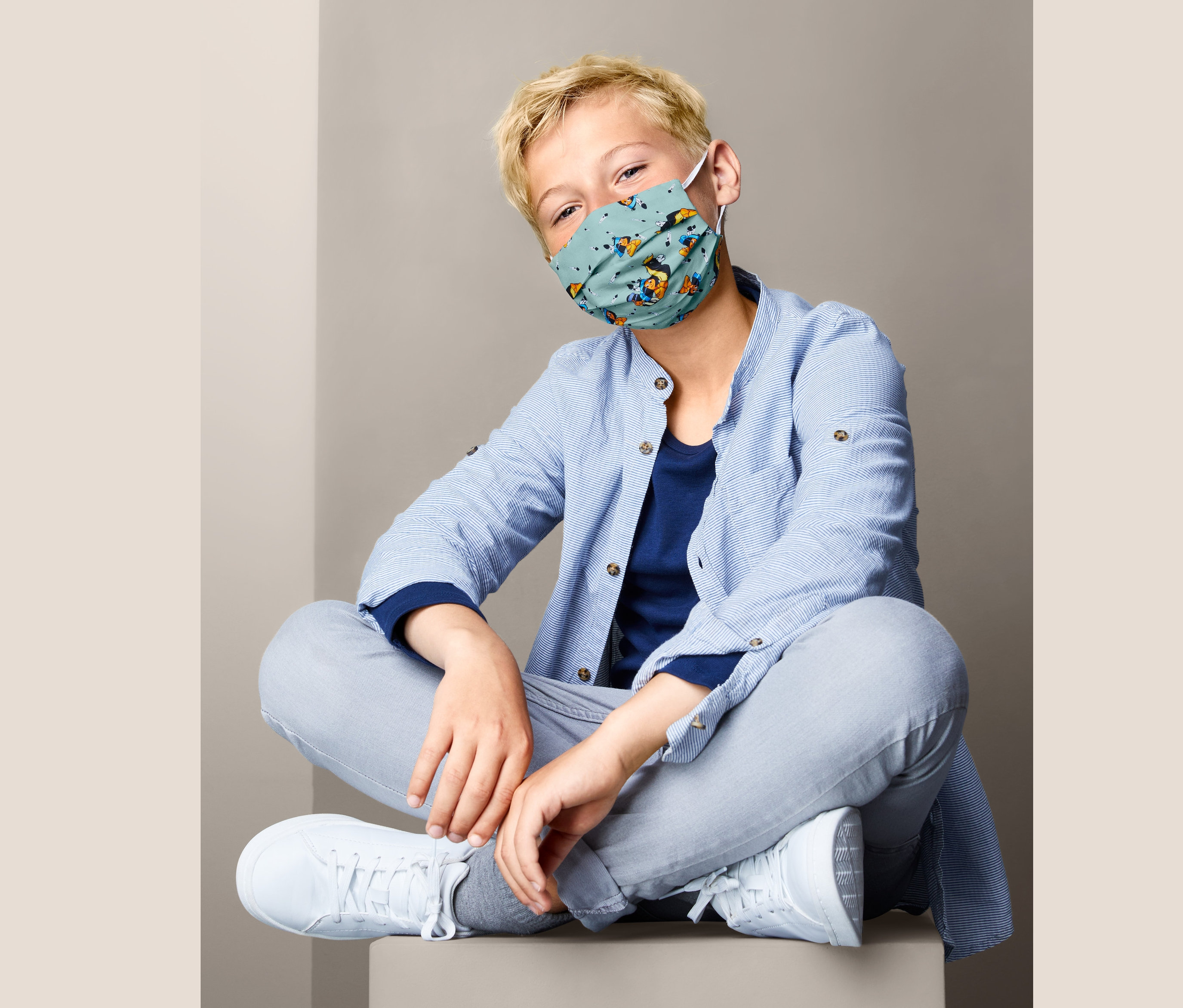 Junge sitzt im Schneidersitz und trägt ein Kids-Masken-Set »Yakari«.