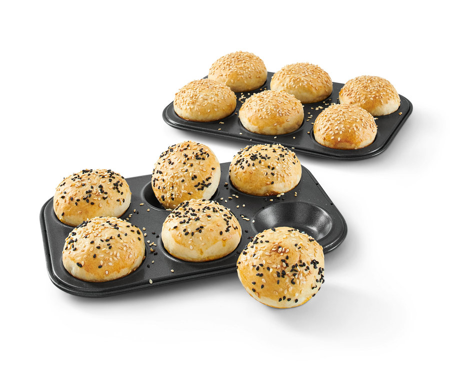 Zwei schwarze Backformen mit gebackenen Mini-Burgern, die mit Sesamkörnern bestreut sind. Mini-Burger-Backset.