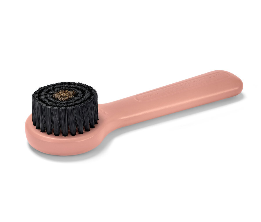 Nahaufnahme einer rosa Kupfer-Gesichtsmassagebürste (Gesichtsbürste).