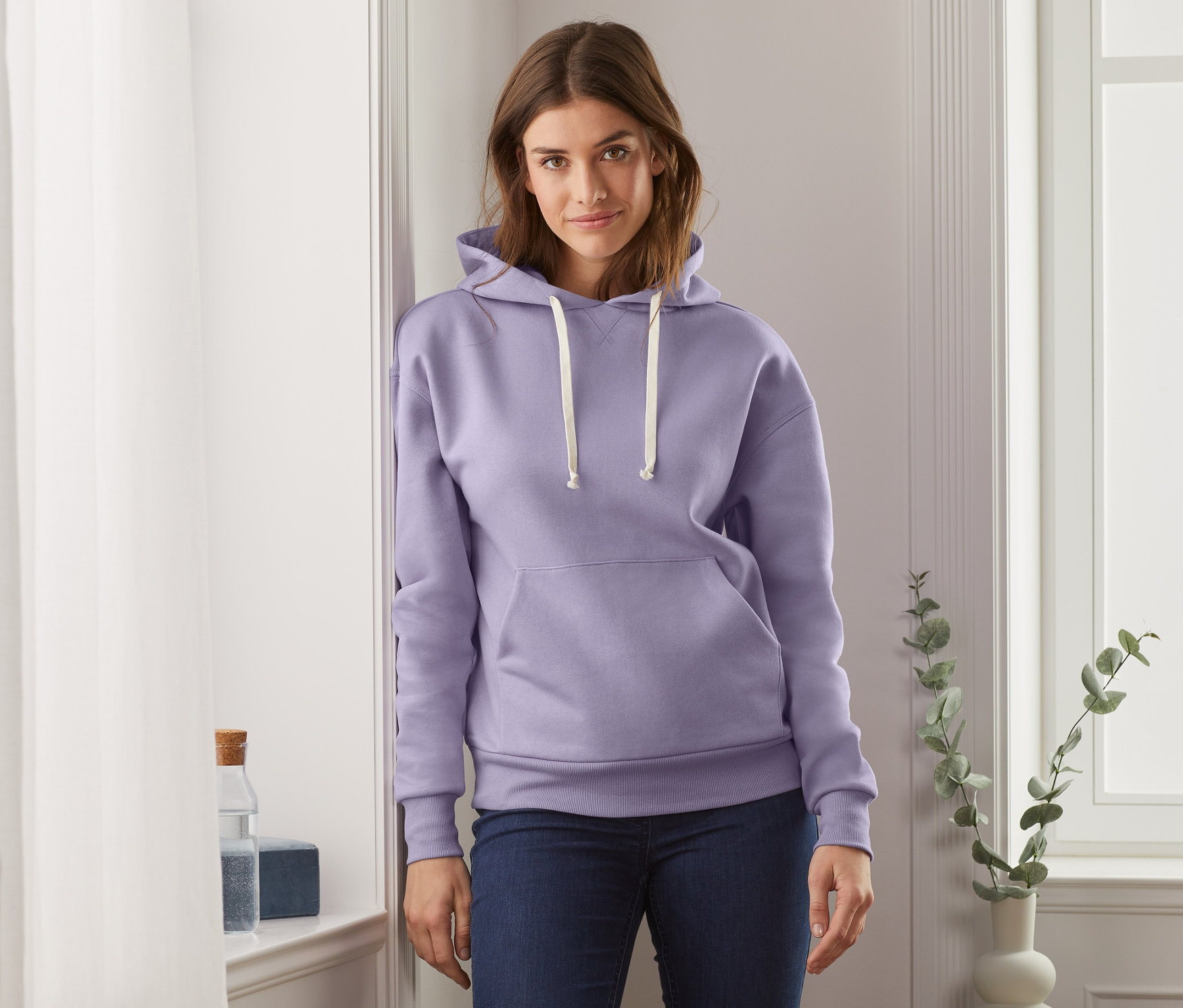 Frau trägt ein fliederfarbenes Kapuzensweatshirt.