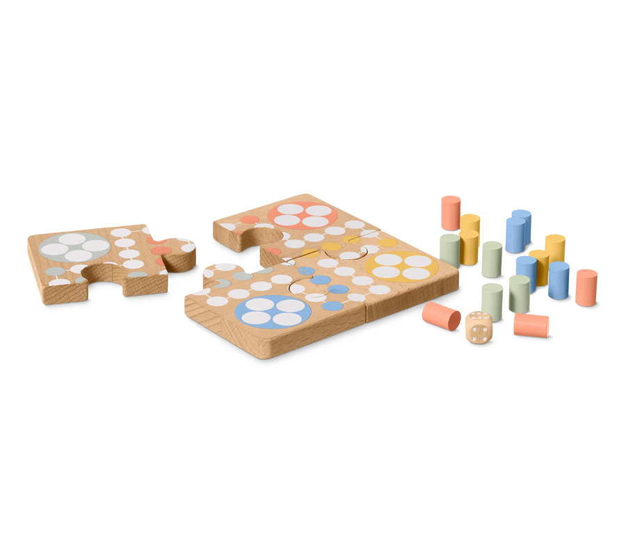 Zwei Ludo-Puzzleteile, ein Satz farbiger Spielfiguren und ein Würfel auf einem weißen Hintergrund.