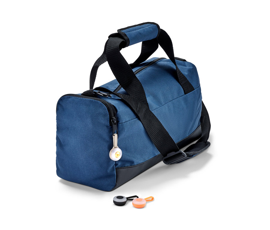 Blaue Sporttasche mit 3 LED-Anhängern, einer am Reißverschluss befestigt und zwei daneben liegend.