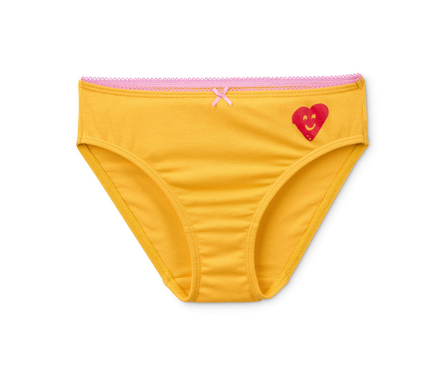 Ein einzelner gelber Mädchenslip aus Bio-Baumwolle aus einem 7er-Set liegt auf einem weißen Hintergrund. Der Slip hat eine rote Herz-Applikation und eine pinke Spitze.