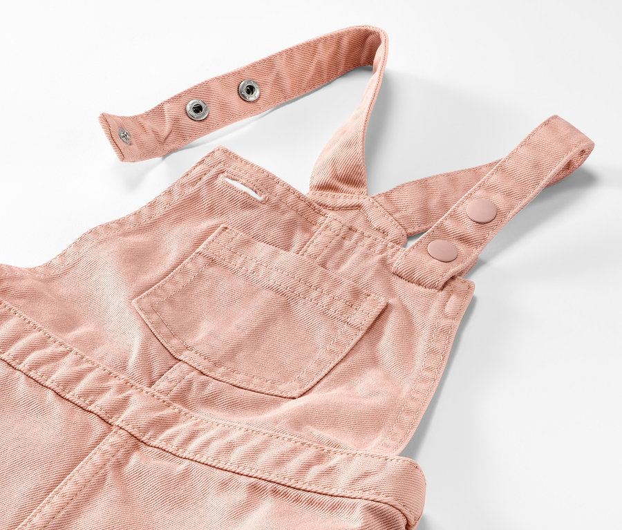 Detailaufnahme eines rosafarbenen Kinder-Latzkleids.