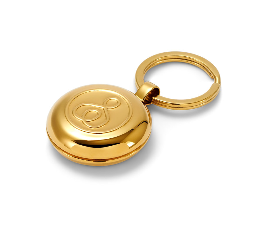 Goldener Pillendosen-Schlüsselbund auf weißem Hintergrund.