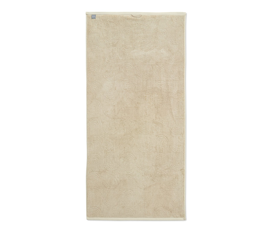Ein cremefarbenes Jacquard-Badetuch.
