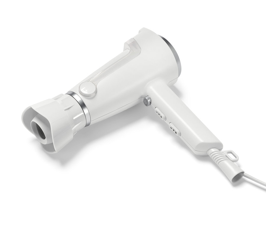 Ein weißer, stellbarer Haartrockner liegt auf einer weißen Oberfläche.