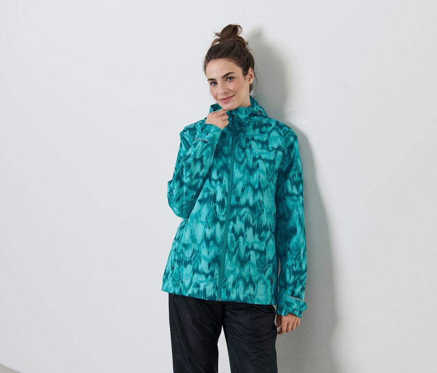 Frau trägt Regenjacke mit Alloverprint.